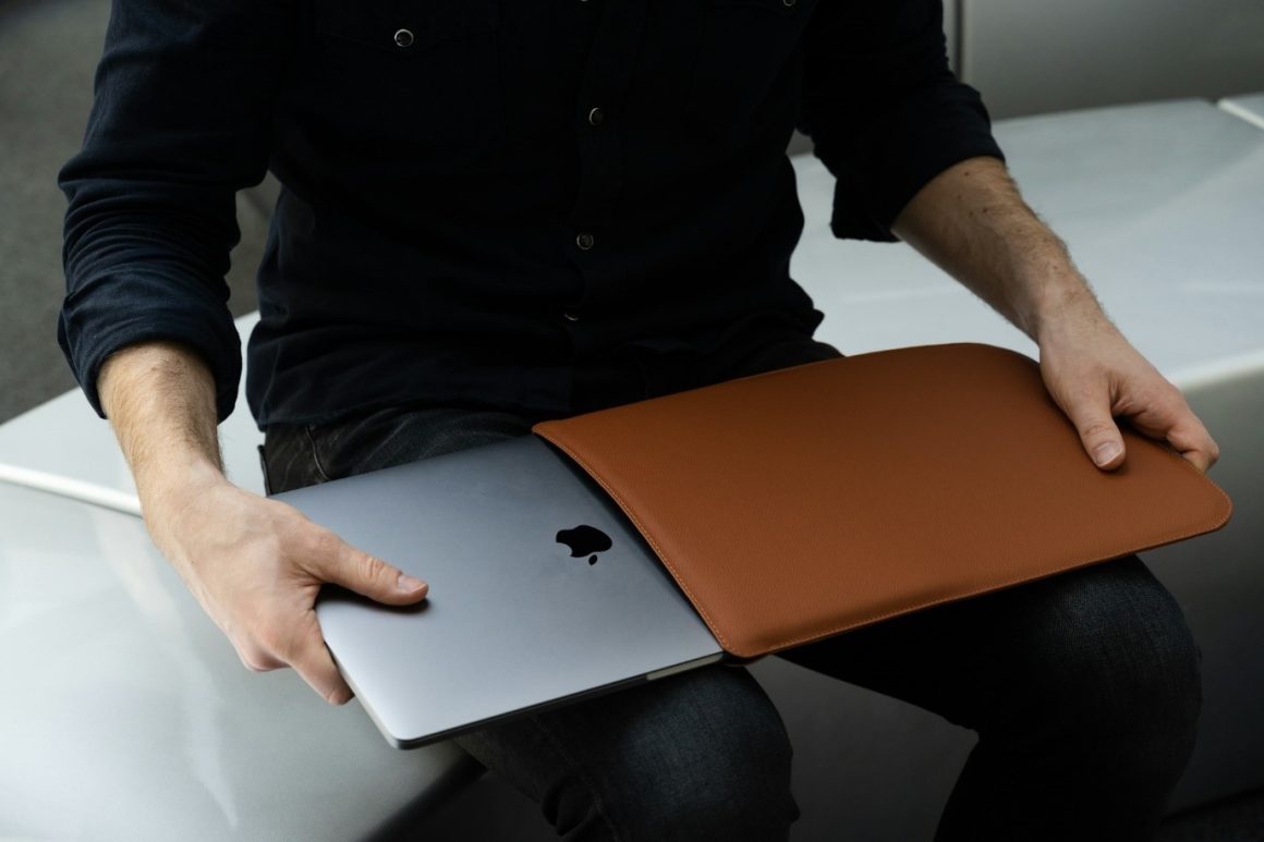 Adding an Apple laptop to a leather case.