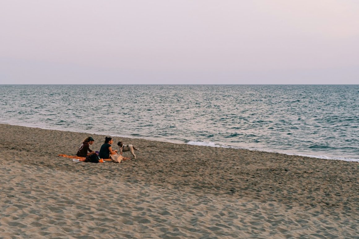 people and a dog relaxing on the beach of Ostia, Rome.