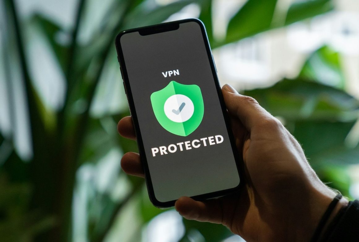 A person holding a smartphone protected by a VPN. 