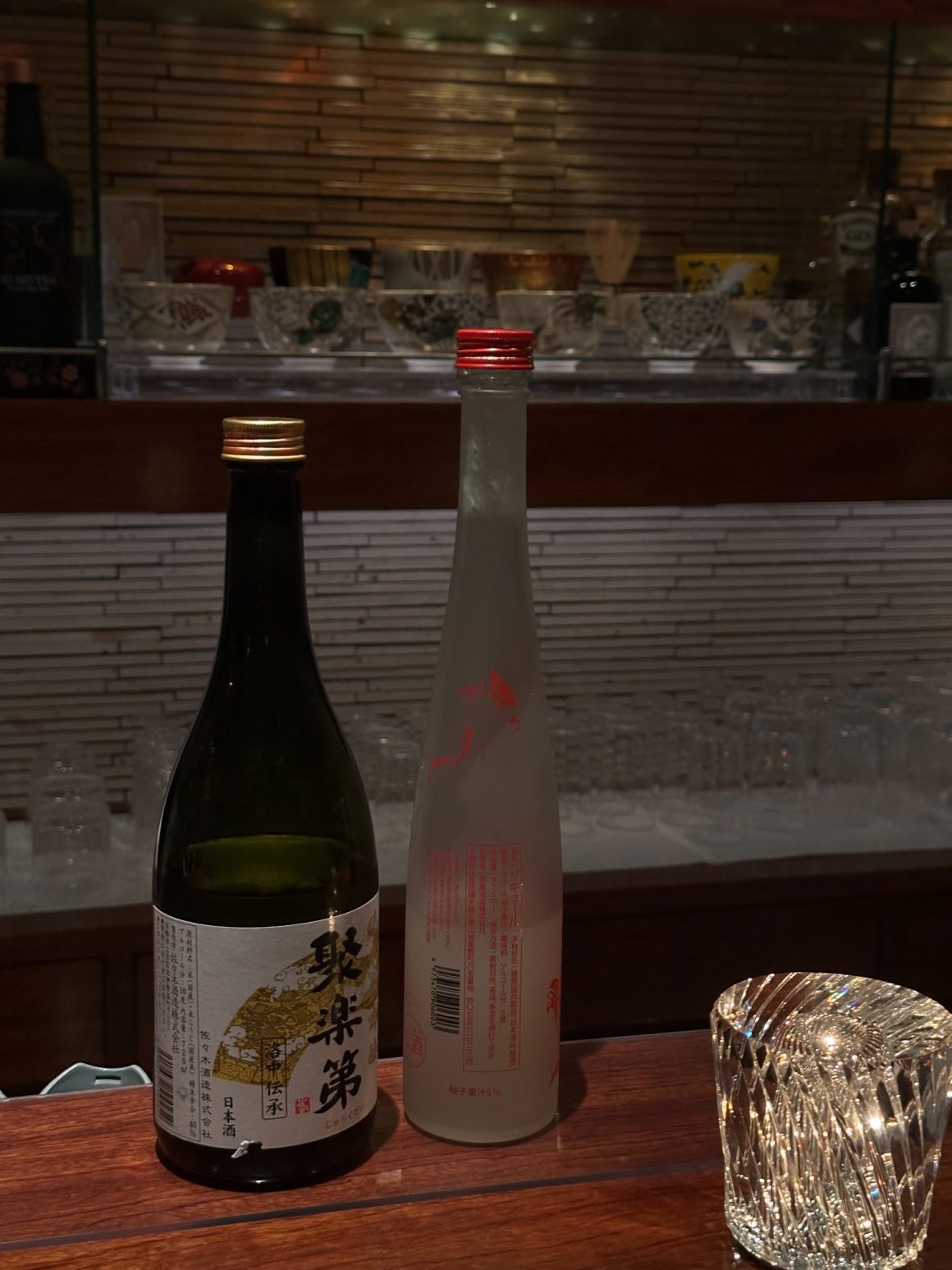 Collection of Japanese sake bottles displayed in a Kyoto bar