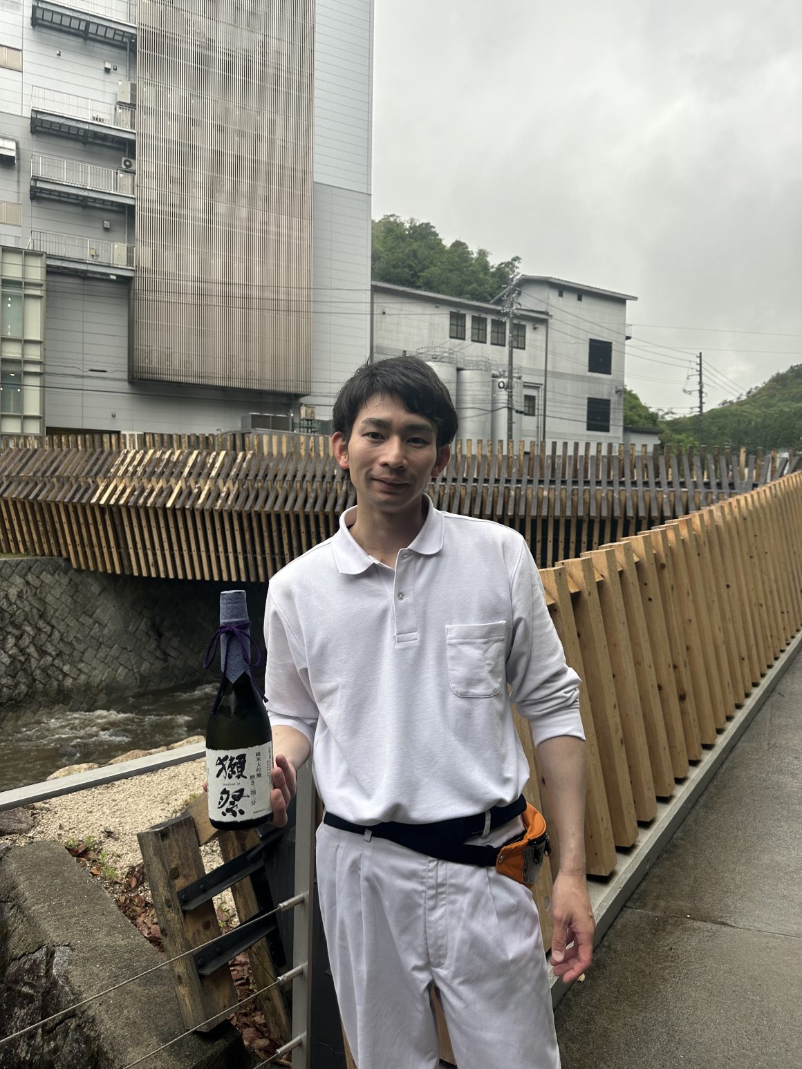 Brewery staff holding a bottle of Dassai sake