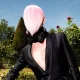 Fredrik Robertsson in a nude masked look and platform shoes, posing against a green wall with dried flowers